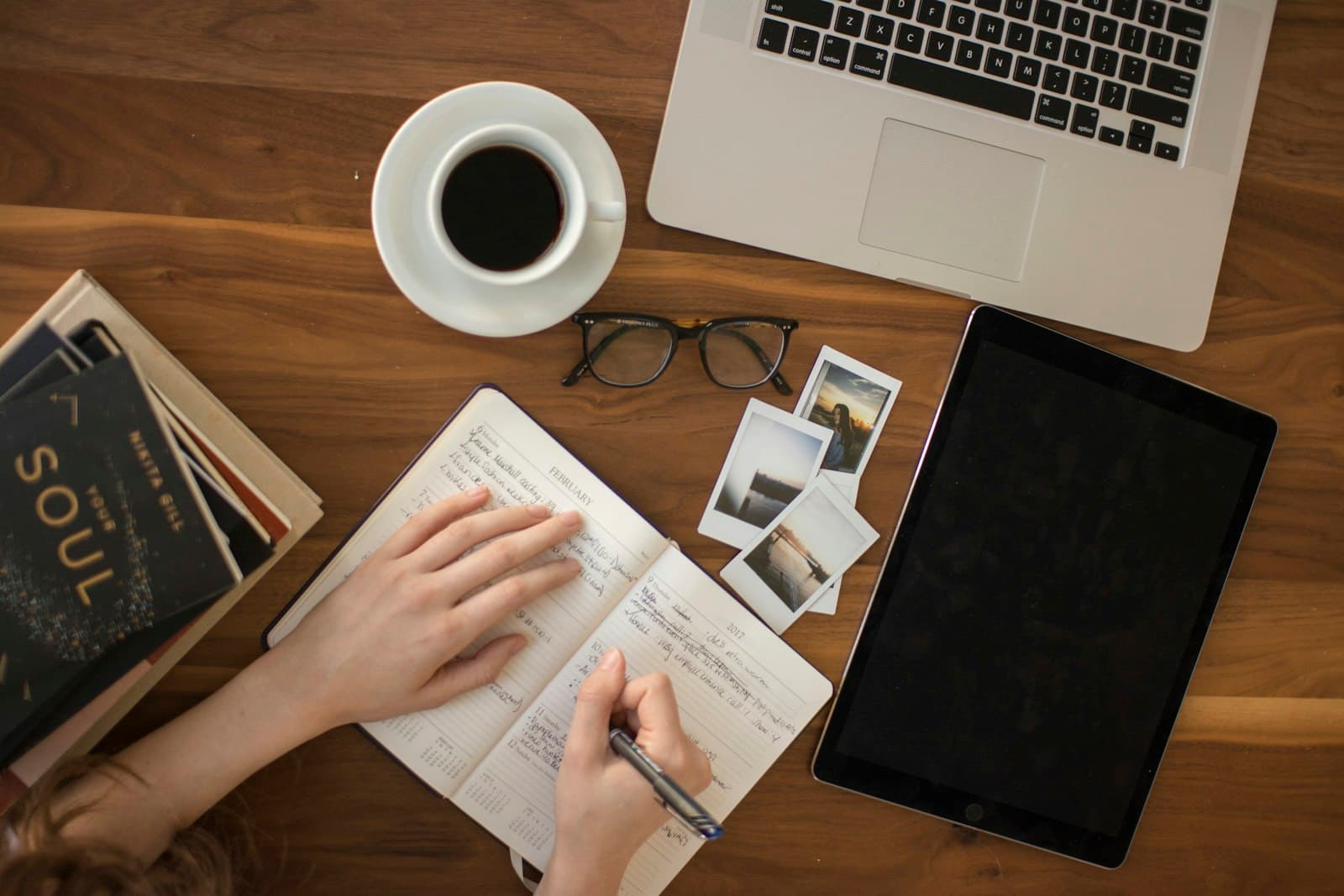 Writing notes beside a laptop and a cup of coffee