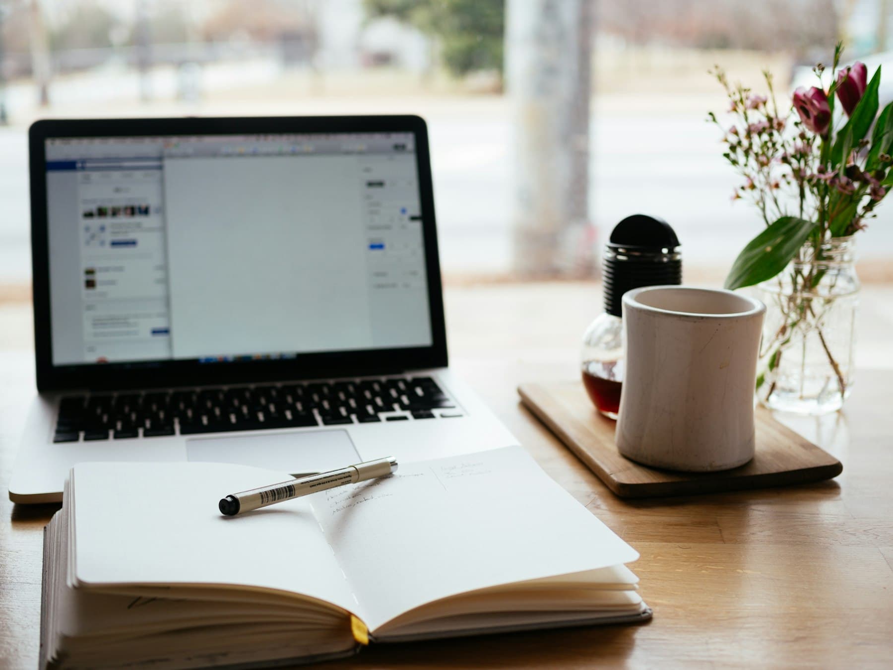 Laptop showing the Moodle dashboard beside a mug