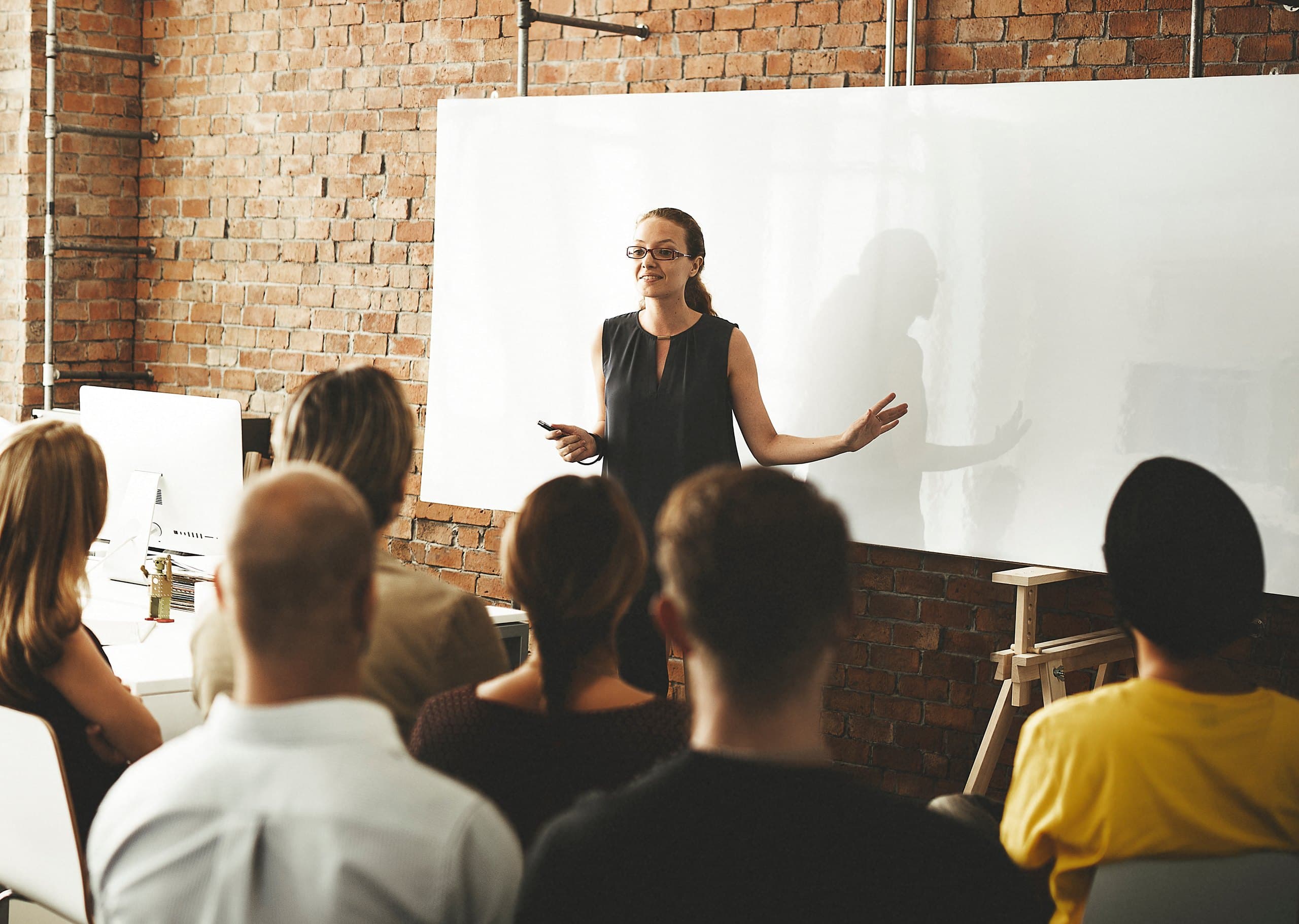 Speaker presenting at a whiteboard to a small group